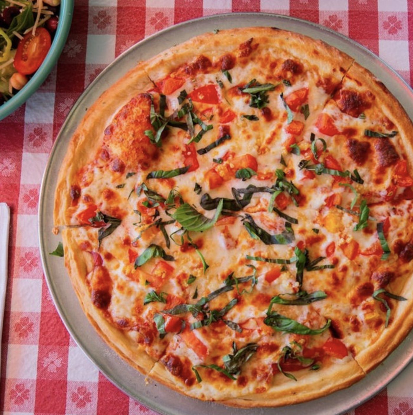 Thin crust pizza on a checkered tablecloth